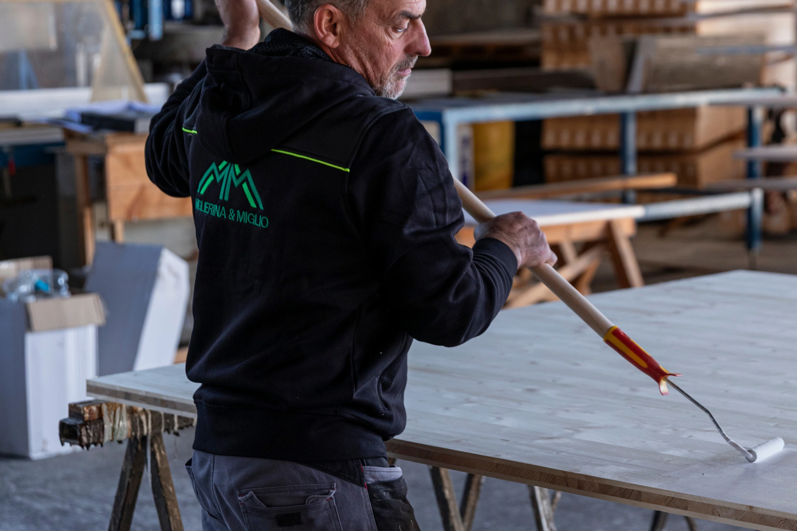 Un impiegato di Miglierina e Miglio che imbianco una coperture di legno